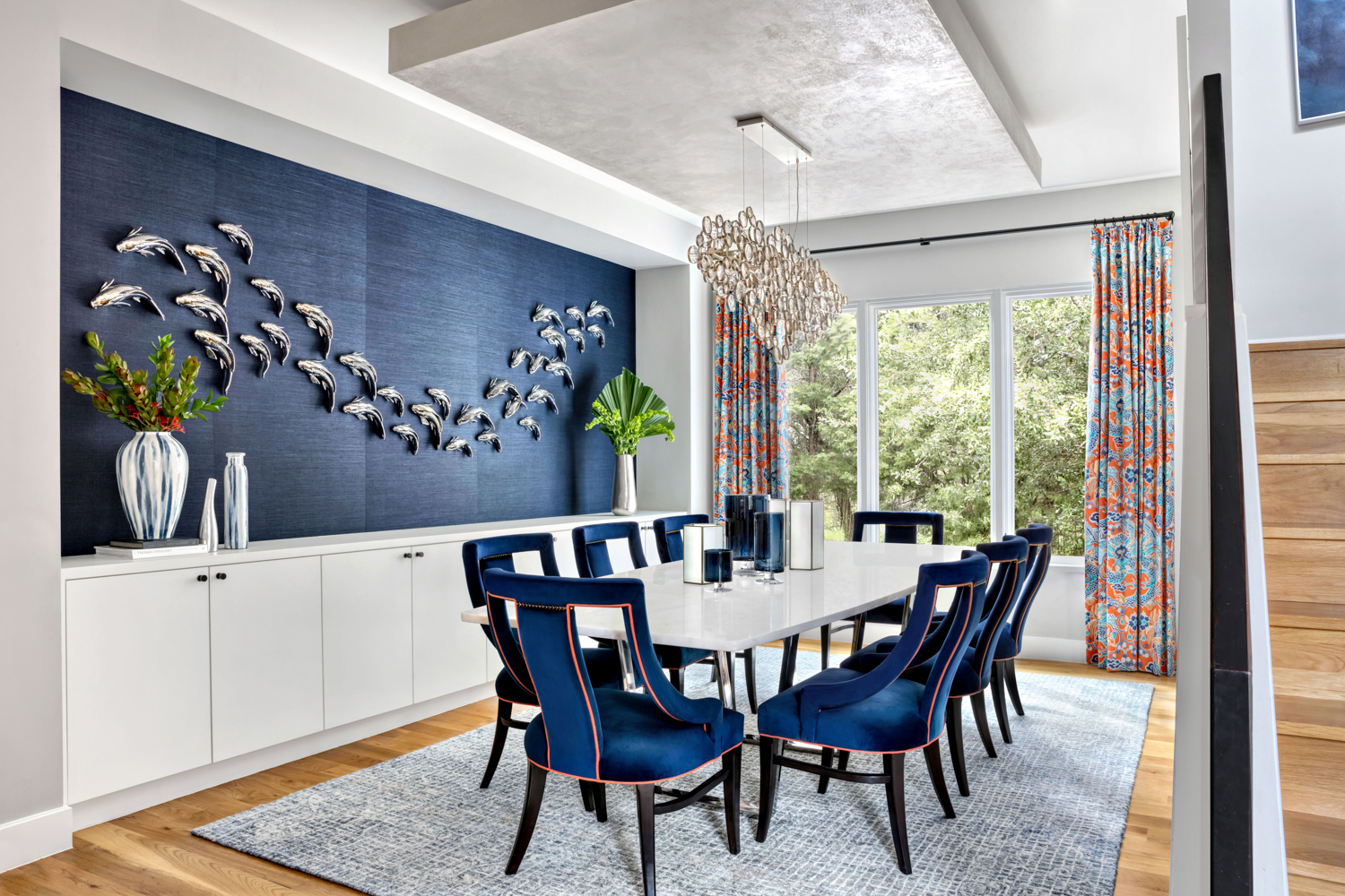 Etch Design Group dining room with blue chairs and blue wall