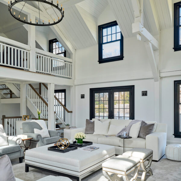 A white and grey great room with black framed windows and doors. RED Winner.